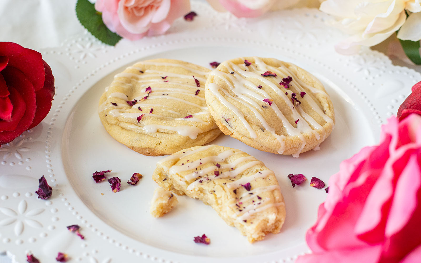 Image of 3 Champagne and Roses Cookies on a plate surrounded by roses