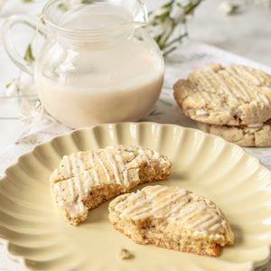 A broken London Fog Latte Cookie rests on a plate, showcasing the delicate texture and flecks of earl grey tea within.